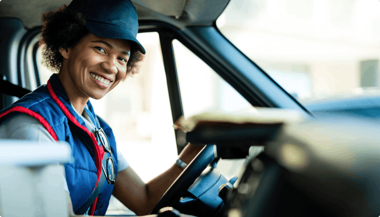 happy-black-female-courier-driving-delivery-van-looking-camera